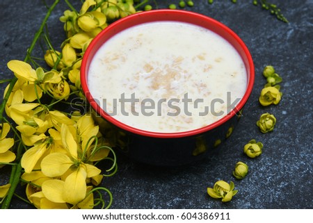 Palada Payasam/ Pradhaman/ Kheer/ Mithai seasonal sweet dish Kerala South India for Onam, Vishu, Bihu festival, bunch of yellow Cassia fistula flowers. Popular Indian dessert /confectionery with rice.