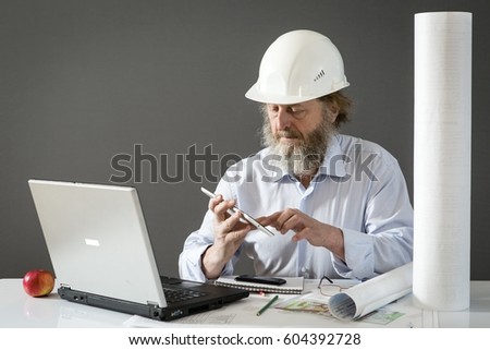 Engineer is a designer In front of the desk in the office of a construction company.