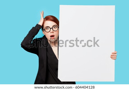 beautiful surprised young woman with big empty poster on the wonderful blue background