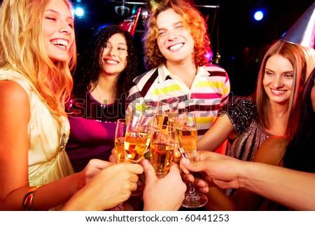 Portrait of group of happy young people toasting at party