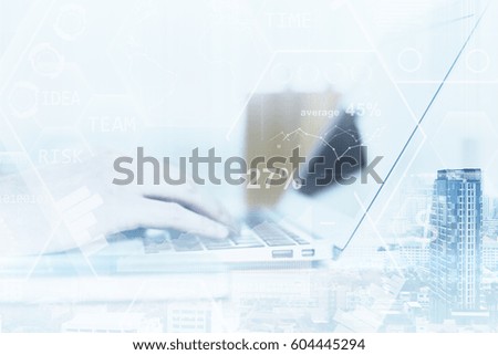 Side view of businessman's hands using laptop with business charts on city background. Double epxosure. Financial growth concept. Filtered image