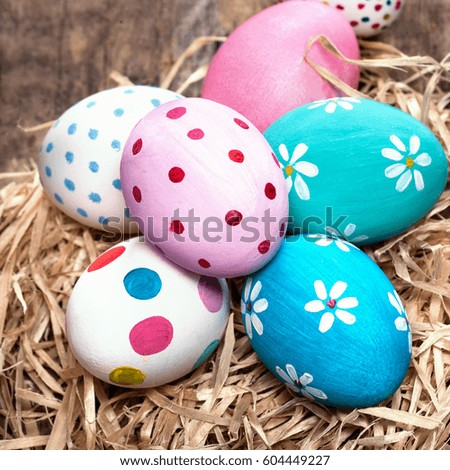 Easter eggs in nest on rustic wooden planks with copyspace. Happy Easter!
