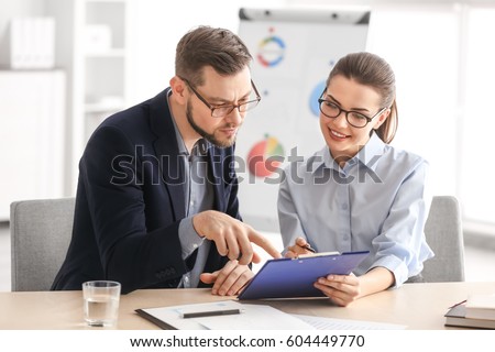 Young managers discussing issues in office Royalty-Free Stock Photo #604449770