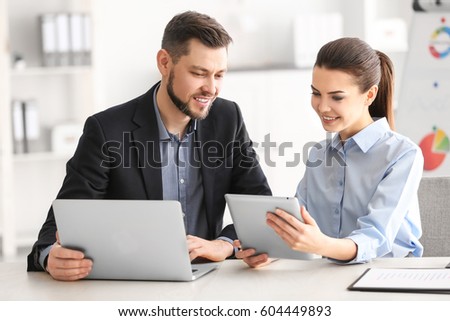 Young managers discussing issues in office Royalty-Free Stock Photo #604449893