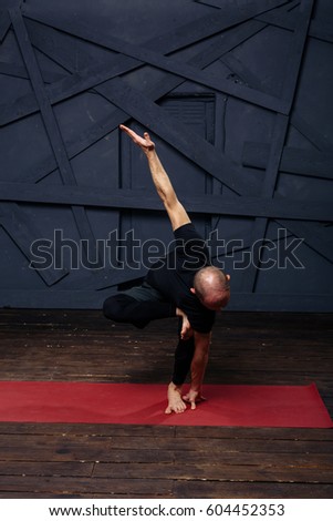Man practicing advanced yoga against a urban background