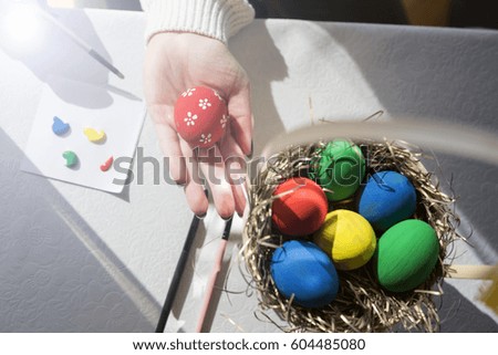 Happy Easter! A female painting Easter eggs. Happy family preparing for Easter. 