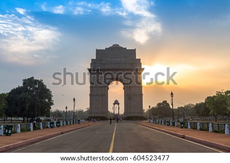 India Gate Delhi at sunrise with a vibrant moody sky. The India Gate, is a war memorial located on the east side of Rajpath road and an important city landmark. Royalty-Free Stock Photo #604523477