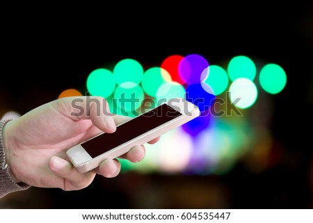 Man use mobile phone, beautiful bokeh as background.