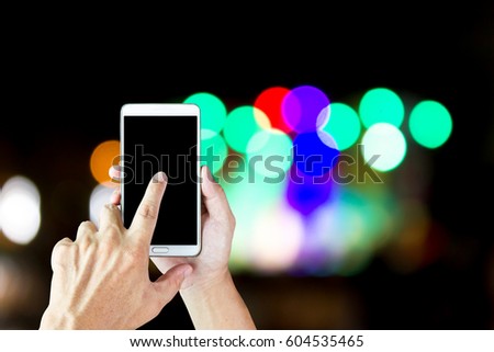 Man use mobile phone, beautiful bokeh as background.