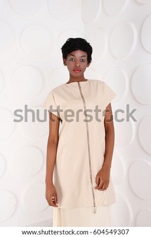 Beauty photo of young elegant african american woman. Girl wearing beige clothes. Stylish evening dress African woman. Glamour makeup. Young beautiful African fashion model with traditional clothes.