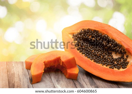 Orange Mature papaya on wood table on green bokeh 