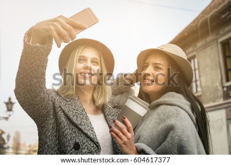 Female best friends taking a picture with the phone.