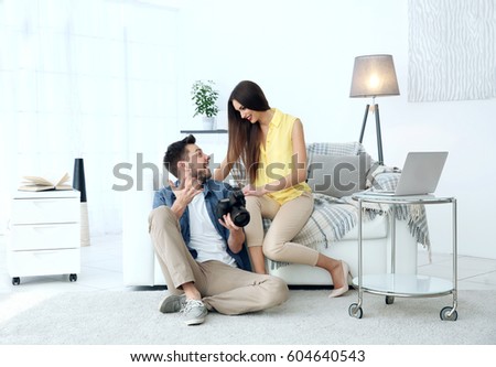 Photographer and model in professional studio discussing picture on camera display