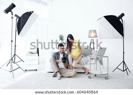 Photographer and model in professional studio discussing picture on camera display