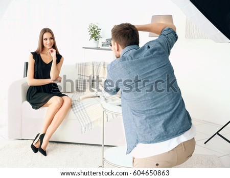 Young beautiful model posing on sofa for professional photographer