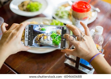 People use smart phone for taking photo food. Breakfast food in the morning.