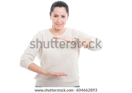 Young smiling lady showing something big between her hands with advetising area isolated on white