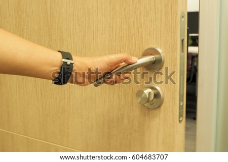woman's hand open the private office's door with do not disturb sign on the door, coming to work