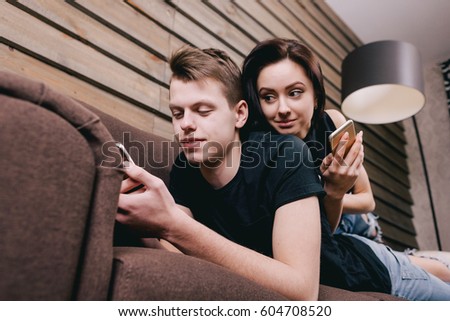 cute couple in bed with smart phone in hands Royalty-Free Stock Photo #604708520
