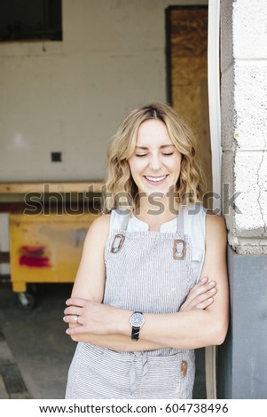 A business owner and craftsman standing in the doorway of her workshop