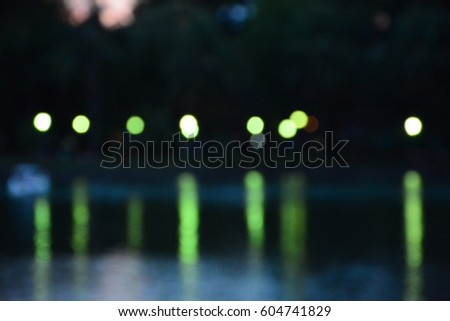 bokeh of green light bulb and the reflection in the river