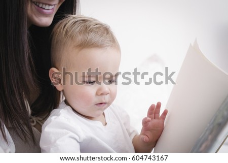 A heavily pregnant woman playing with her young son