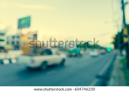 image of blur car on road on evening time for background usage. (vintage tone)