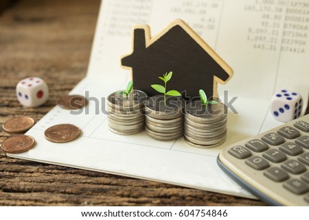 stack coins and house wood model  green plant growth,concept idea for save and growth money