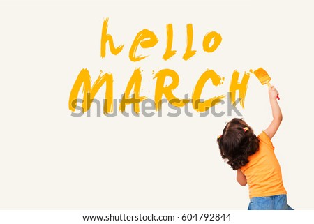 Cute little girl drawing : hello MARCH with painting brush on wall background