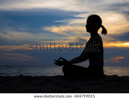 Silhouette of a woman playing yoga on twilight. Sunset sky background