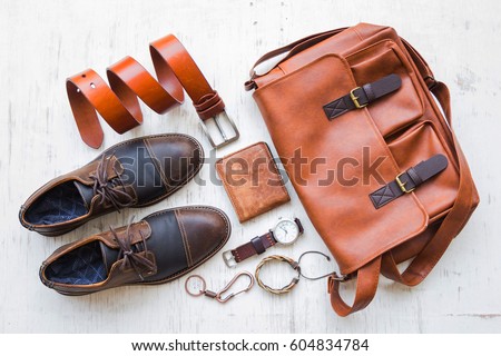 Men's casual outfits with leather accessories on white rustic wooden background, beauty and fashion concept Royalty-Free Stock Photo #604834784