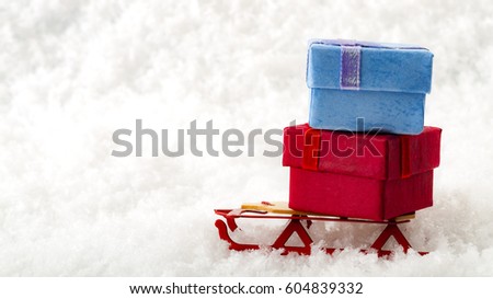 Christmas gift and holiday shopping concept with red and blue Christmas gift boxes decorated on Santa s sledge with copy space isolated on white snow