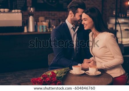 Happy romantic man and woman  sitting in a cafe with flowers drinking coffee Royalty-Free Stock Photo #604846760