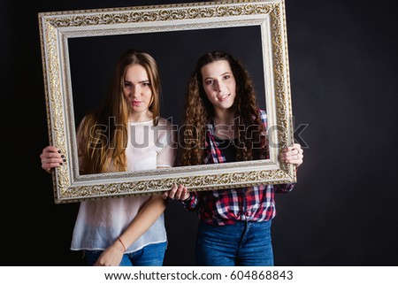 studio portrait of Beautiful young caucasian women sisters best friends bff isolated on black background, girls goof goofing around, cut didoes, In the frame for a picture, goofy face, good mood