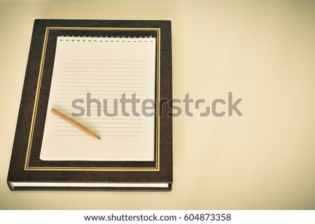Book on a white background with a pensil