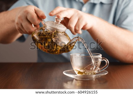 pour hot herblal tea into cups