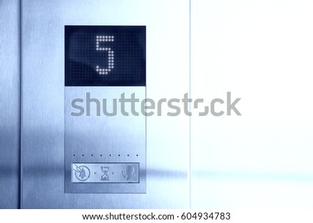 LCD display shows number of fifth floor in metal elevator