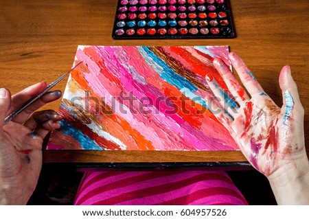 Art and painting concept - woman with painted hands, focus on hands
