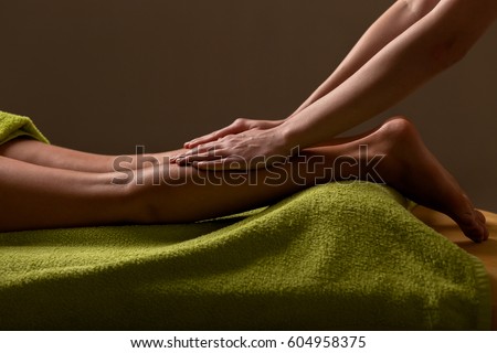 close-up masseur hands doing foot massage. low key photo