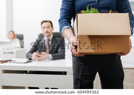 Confident employee leaving the office with his personal stuff Royalty-Free Stock Photo #604989362