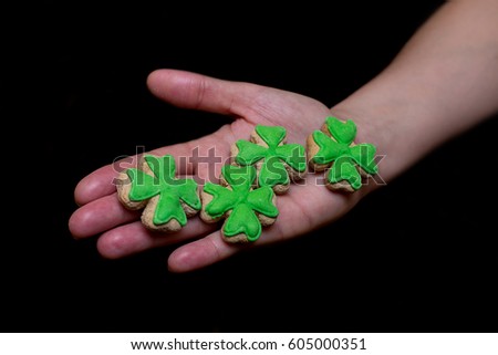 Four clovers cookie gingerbread with green mastic on palm close-up St. Patrick's Day
