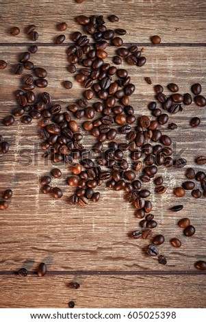 Black coffee beans on a wooden background, in dark tones