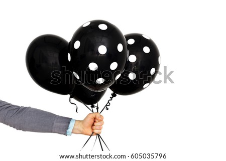 Caucasian man holds in hand black balloons. Present for sad event
