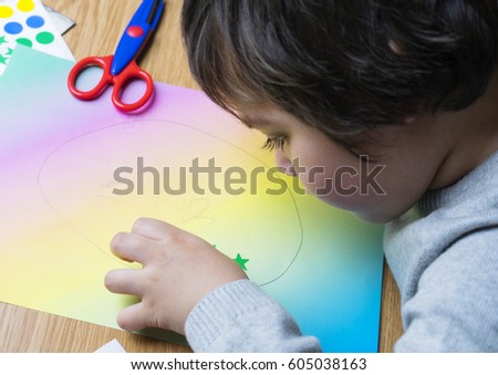 little boy drawing picture for easter egg at home and having fun with family