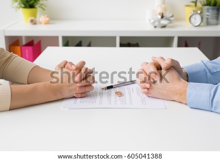 Couple going through divorce signing papers Royalty-Free Stock Photo #605041388
