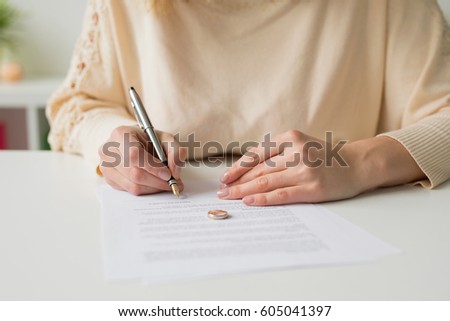 Woman going through divorce and signing papers