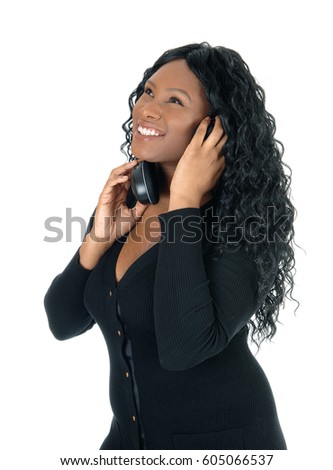 A smiling young African American woman listening with her headphones
to music, smiling, isolated for white background.
