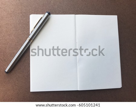empty page of notebook with pen on wooden table. soft focus