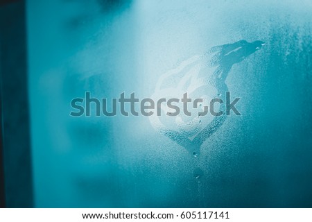 Happy smile drawn on the fogged glass window background. Close up image of condensated surface
