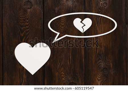 Paper heart is thinking about broken one on wooden background. Abstract conceptual image.